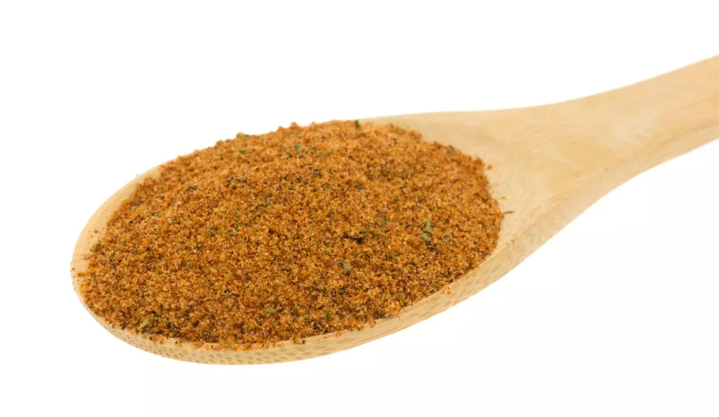 Chipotle chili powder close up on a wooden spoon.  