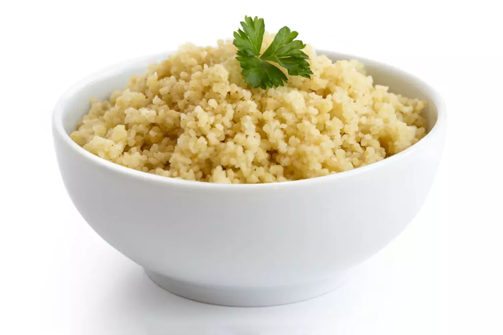 Close up shot of couscous in a bowel with parsley.