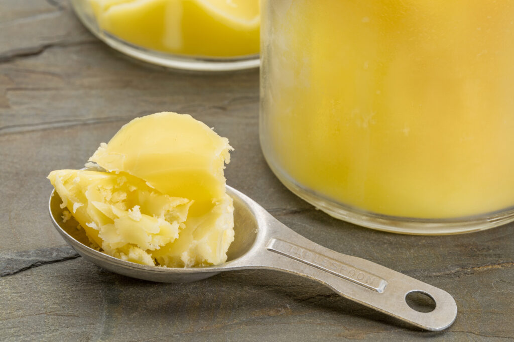Close up of ghee in a measuring spoon.  Like butter, this is a versatile and flavorful ingredient making it a great bacon grease alternative.  