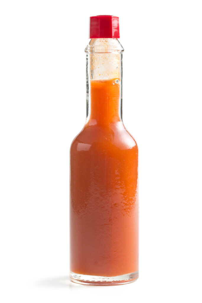 Close up of a bottle of hot sauce.  When used with caution, this can be a great substitute for jalapeño peppers. 