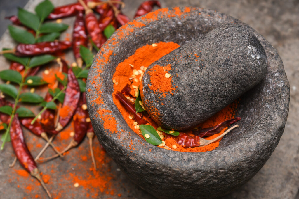 Kashmiri chili powder in a traditional stone mortar