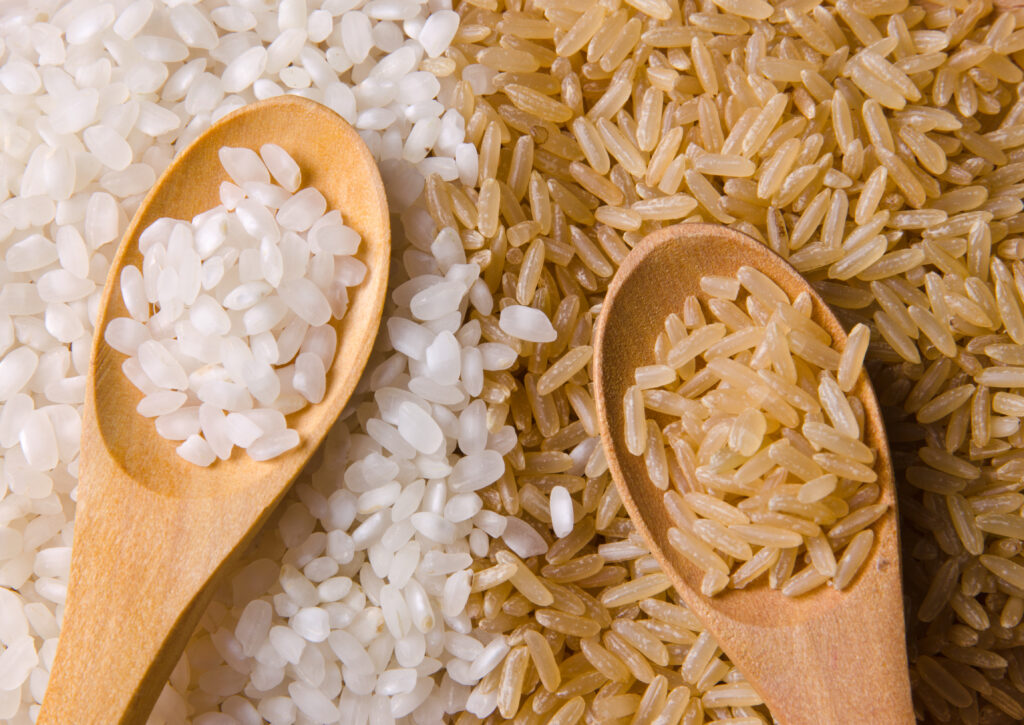 Close of photo of white and brown rice grains next to each other, showing the similarities and contrasts of each. 