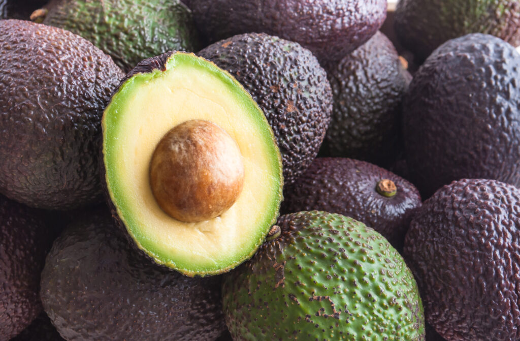 Grouping of avocados.  You can tell the ripeness of an avocado by it's color, texture and firmness.