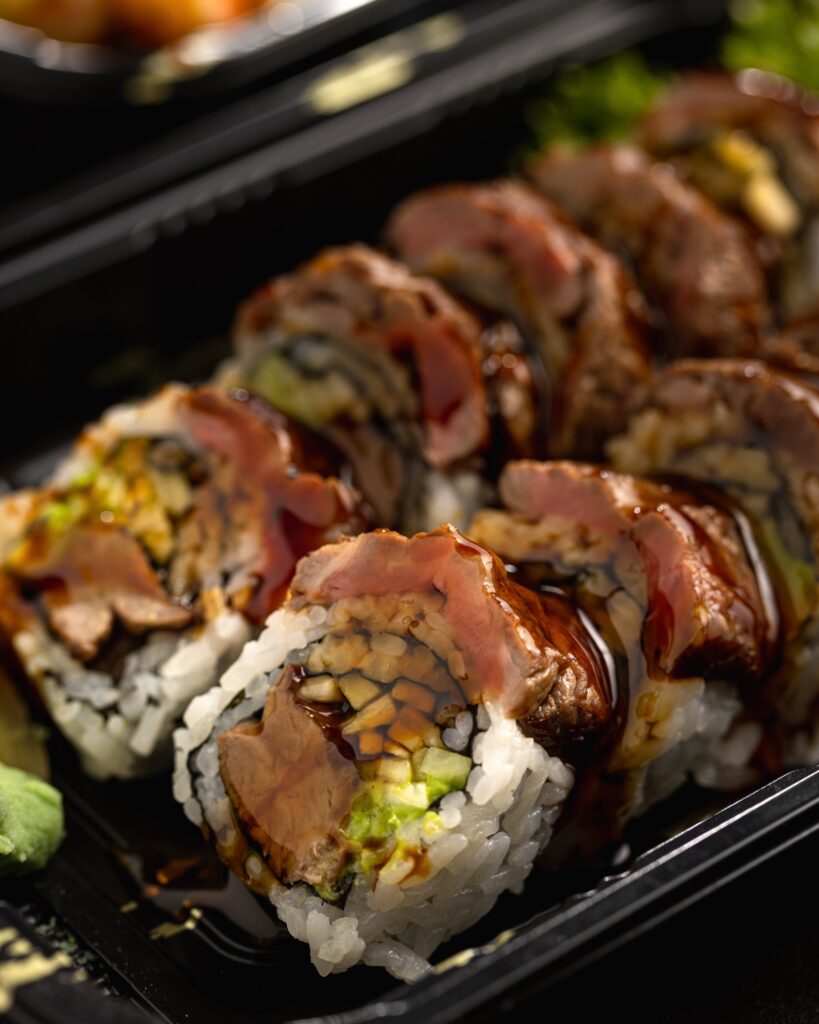 Chicken teriyaki rolls arranged on a platter.  This dish fuses together two traditional Japanese cooking styles in a great cooked sushi roll. 