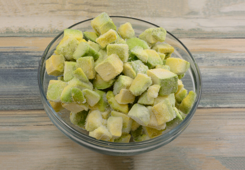 Frozen cut avocado in a bowl. Avocados store well in a freezer and can last around one month if cut.  If uncut, avocados can last up to three months in the fridge.