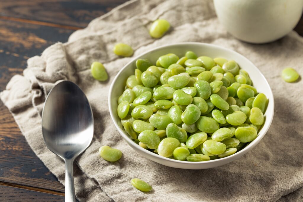 Lima beans in a bowl on a cloth.  Lima beans have a similar taste and texture to chickpeas, making them a great chickpea replacement