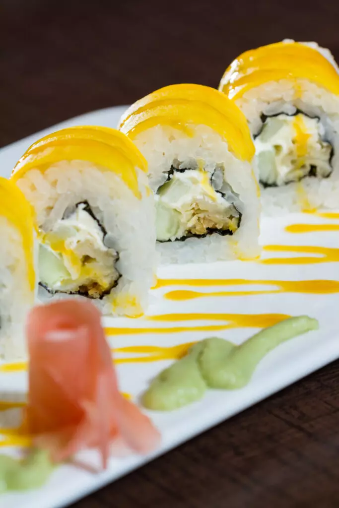 Closeup of the Mango roll drizzled with mango puree.  This colorful and sweet dish is a great cooked sushi option.
