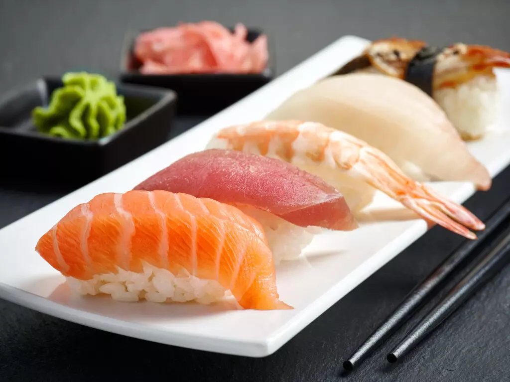 Close up of various types of nigiri sushi.  Nigiri is one of the four main types of sushi and is defined as a ball of sushi rice covered by a piece of fish, meat or other topping. 