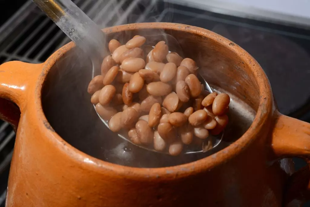 Hot pinto beans in a ceramic pot.  Pinto beans work as a great chickpea replacement in stews, casseroles and dips.