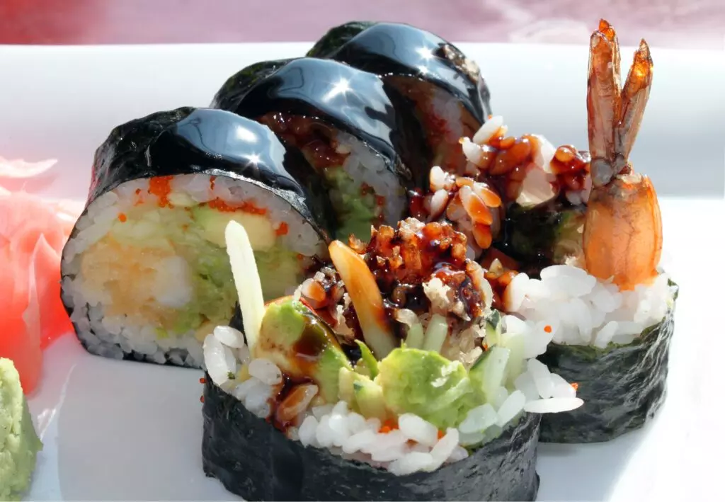 Shrimp tempura roll on a white plate.  These delicious rolls are a popular cooked sushi.