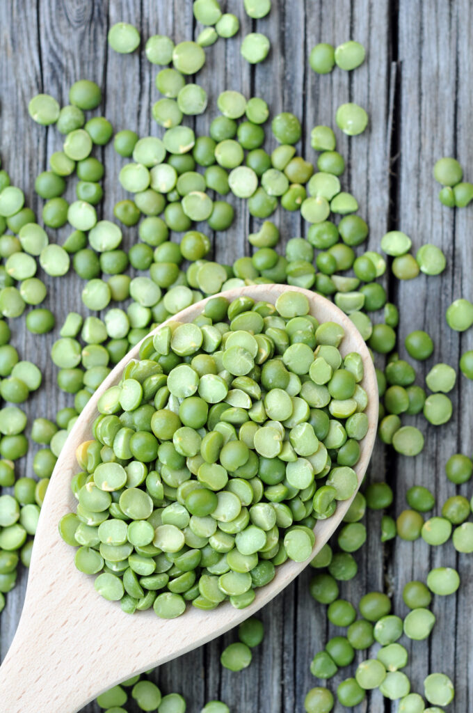 Close up of split peas on a wooden spoon
