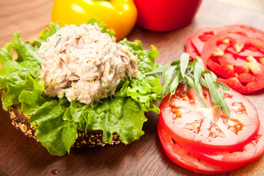 Tuna salad on an open face sandwich with tomatos.  Properly stored, tuna salad will last in the fridge for 3-5 days.