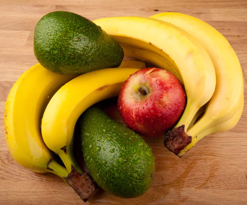 Avocados with bananas and apples.  Storing with ethylene emitting fruits such as apples and bananas can help speed up the ripening of avocados.