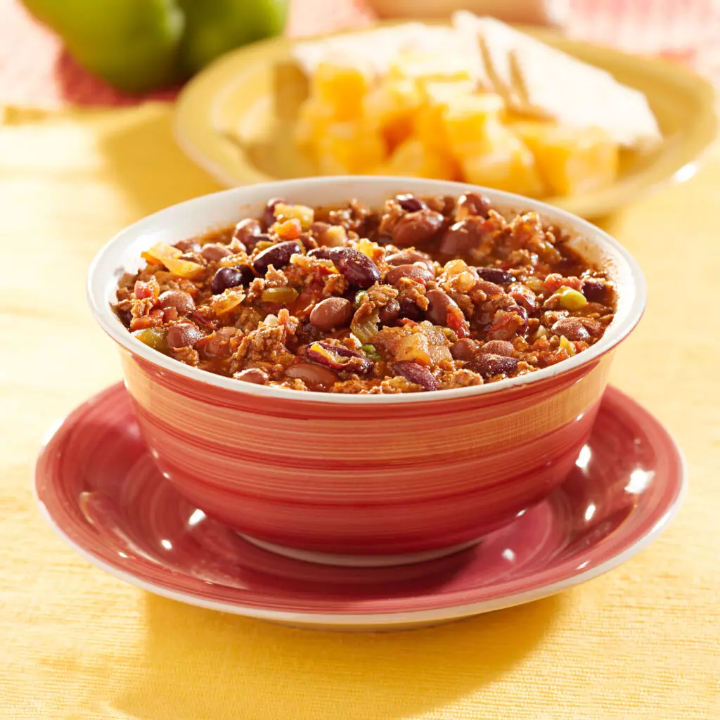 Close up of chili in a red bowl.  You can easily tell if chili has gone bad by looking at it's appearance, texture, smell and taste. 