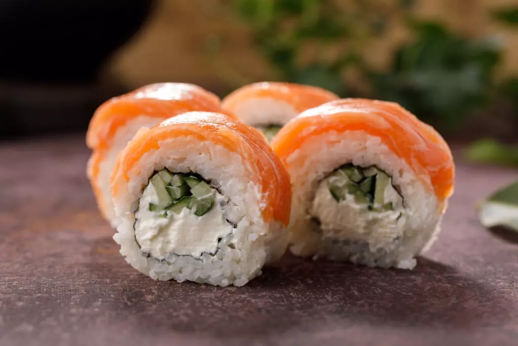 Close up of Philadelphia rolls with the salmon draped over the top instead of being included in the roll. 