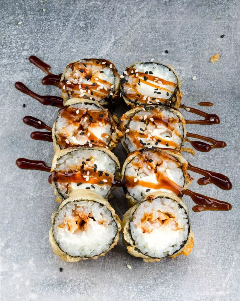 Eel sauce (unagi sauce) drizzled over maki sushi rolls.
