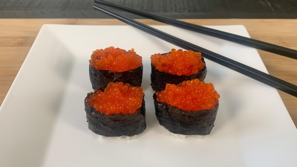 Ikura Sushi on a plate with chopsticks