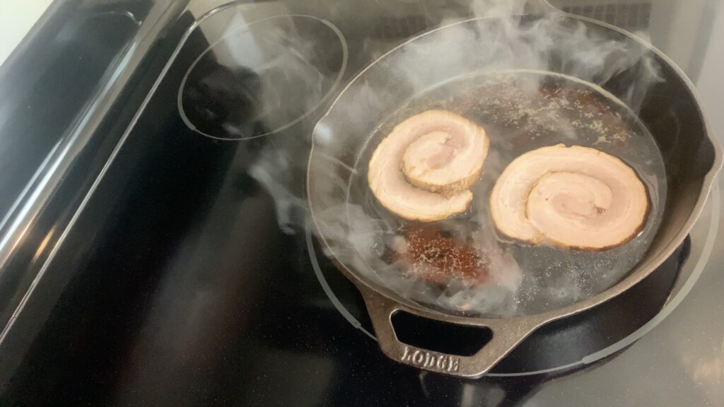 Heat chashu pork in its cooking liquids on a skillet
