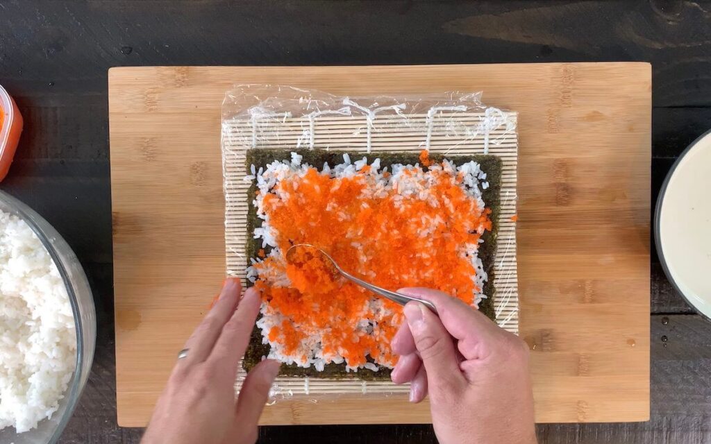 Adding tobiko or masago to the rice.  Tobiko or masago gives the Boston roll it's signature red or orange color.