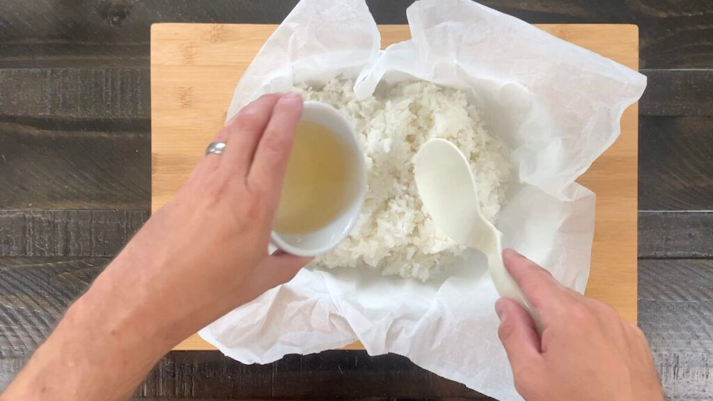 Mix sushi vinegar into the sushi rice using a chopping motion until the vinegar until fully absorbed into sushi rice.