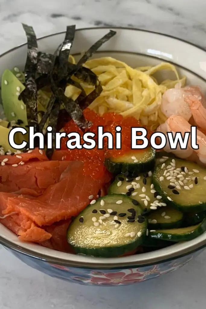Close up shot of a chirashi bowl using kinshi tamago, ikura, shrimp, cucumber salad, smoked salmon, diced nori sheet and rice.
