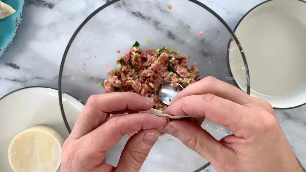 Using your fingers, crimp the gyoza wrapper shut to seal the dumpling.