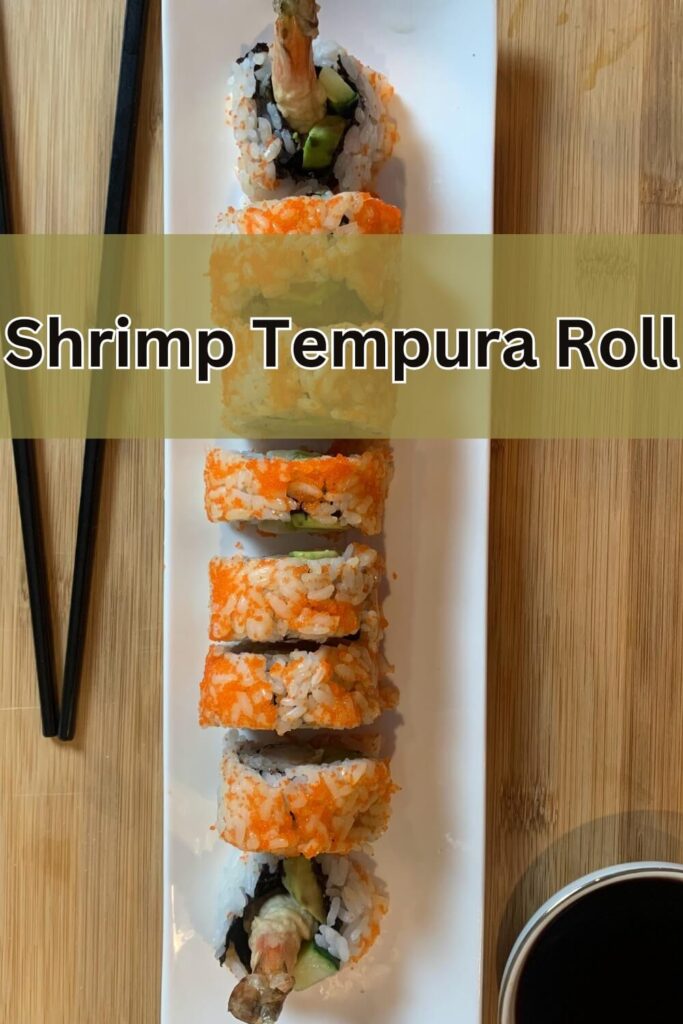Shrimp Tempura roll sushi on a white plate placed on a bamboo cutting board. Also in the picture are black chopsticks and soy sauce