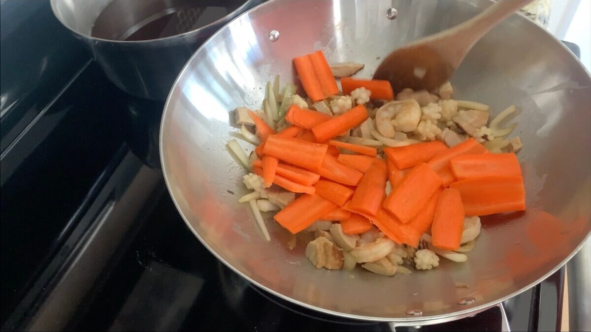 Add carrots to the wok and stir-fry for one minute.