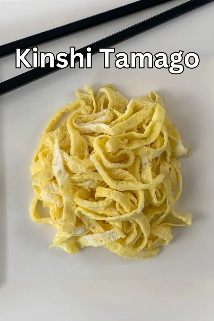 Kinshi Tamago vertical close up on a plate with chopsticks.