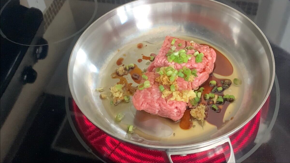 To start the filling of the harumaki, add the pork, sesame oil, ginger, mirin, green onions, salt and pepper to a skillet and cook until pork is brown. 