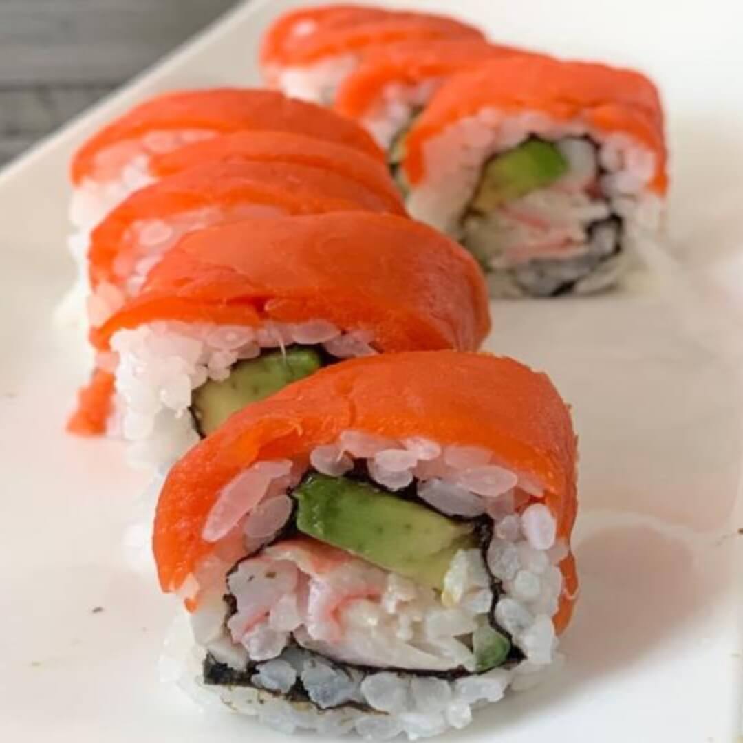 Close up of Alaska roll sushi on a white plate.