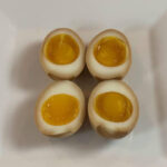 Ramen eggs on a white plate square thumbnail for recipe.