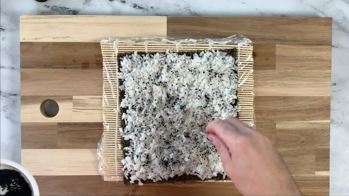 Sprinkle black sesame seeds onto the rice before flipping the nori sheet.  I think this makes the dynamite roll makes the presentation pop. 