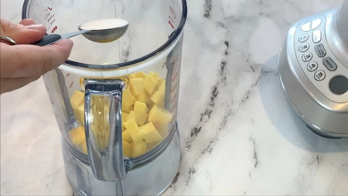 Add lemon juice and sugar to the mango chunks in the blender. 