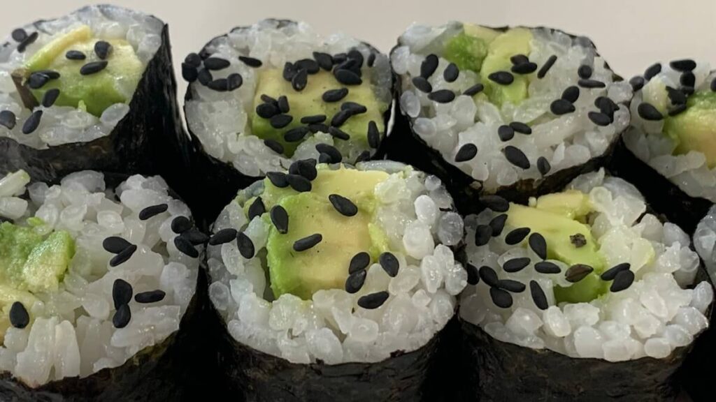 Close up shot of avocado rolls on a white plate