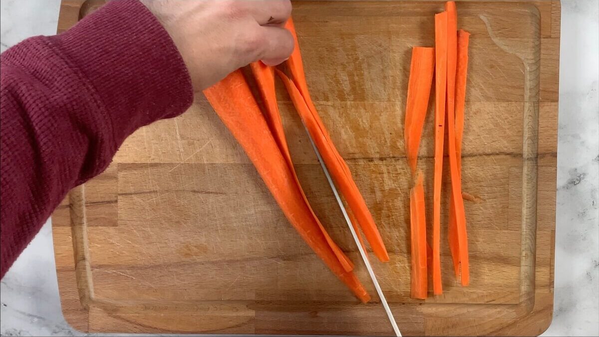 Slice carrots into strips julianne style for the vegetable roll sushi.