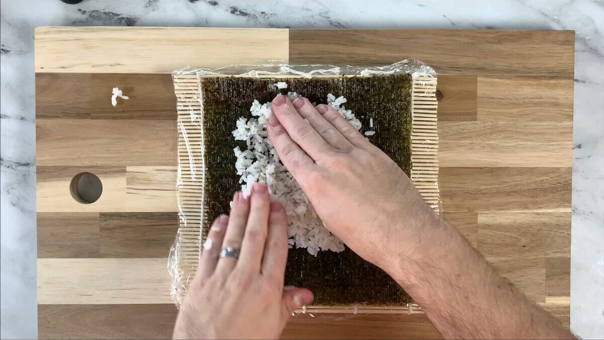 Spread the rice onto the nori sheet for the dynamite roll.