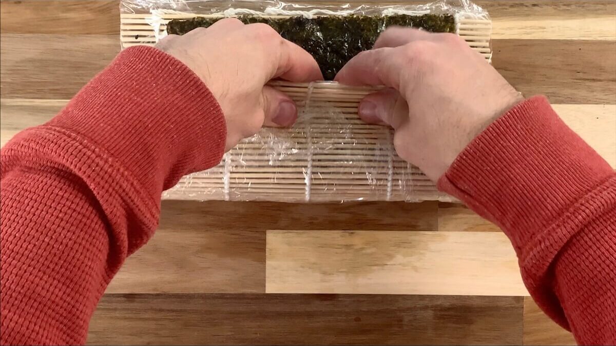 Using the sushi mat as your guide, roll the the spider roll. 