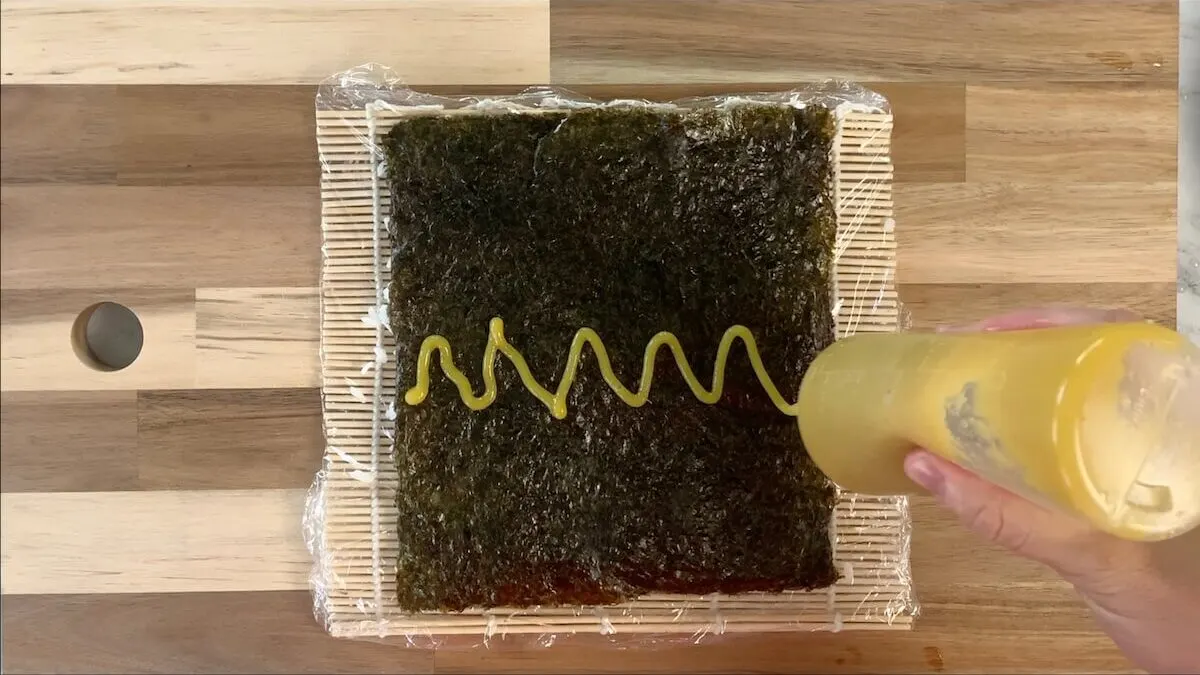 Add a line of sweet mango sauce to the nori sheet before adding the fillings. 