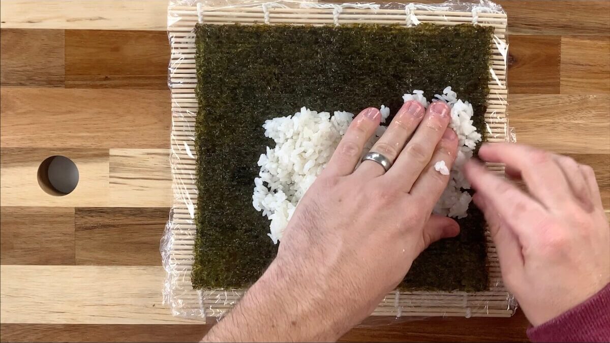 Spread rice onto the nori sheet. 