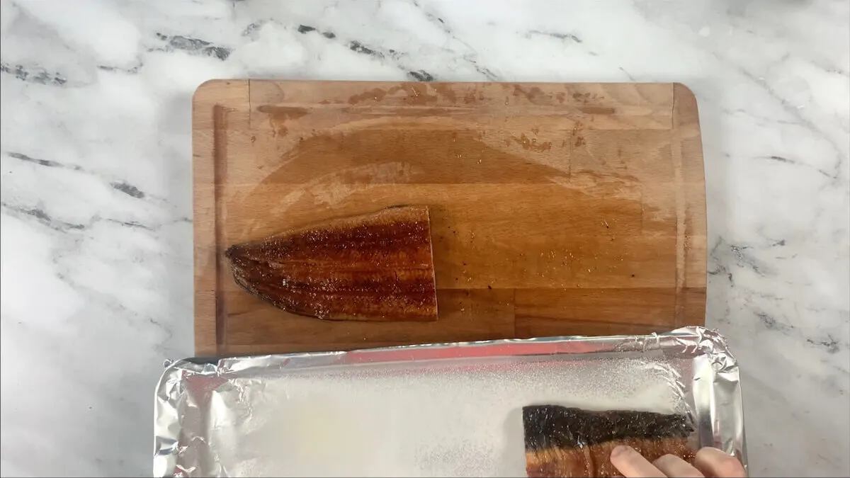 Place the eel skin side up on a greased baking sheet and broil on high heat for six minutes. 