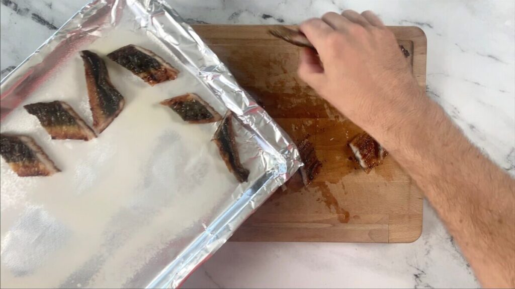 Place eel slices skin side up on a greased baking sheet and broil for 6 minutes on high heat. 