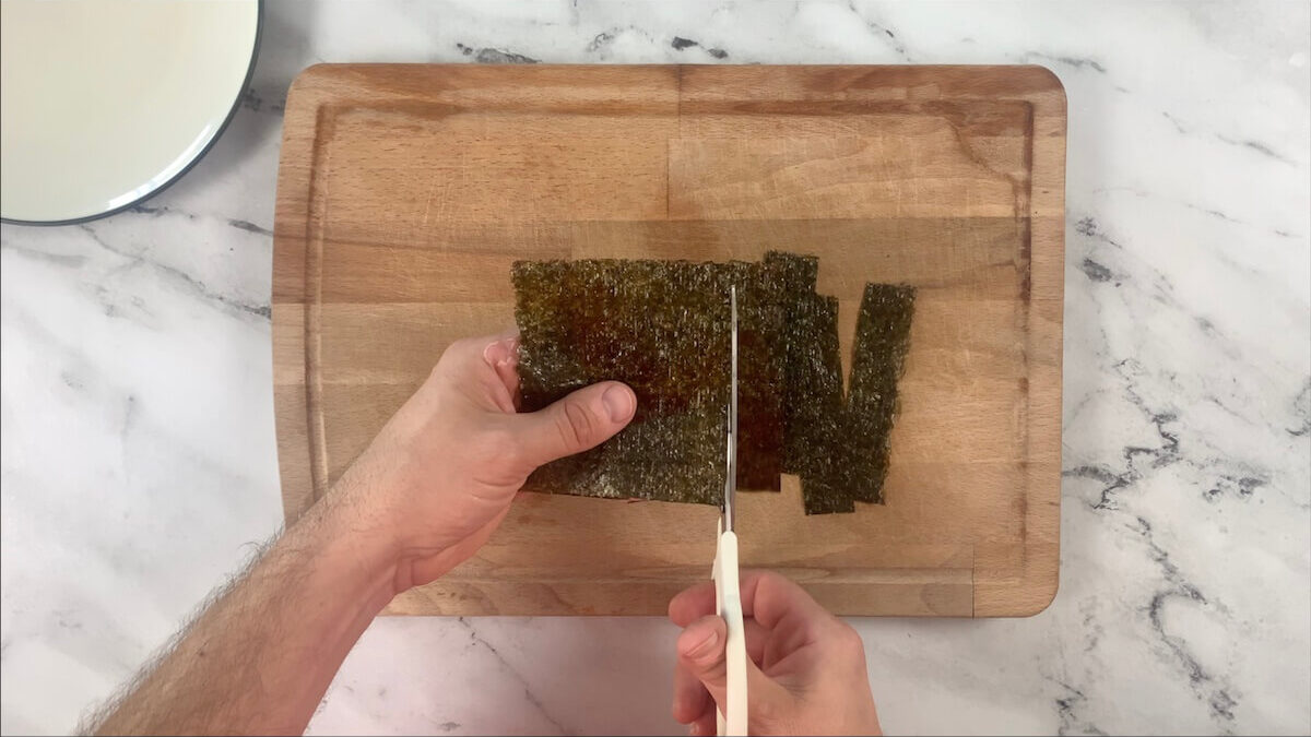 Cut nori sheet into strips.  These will be used to hold the eel to the rice ball inthe unagi nigiri.