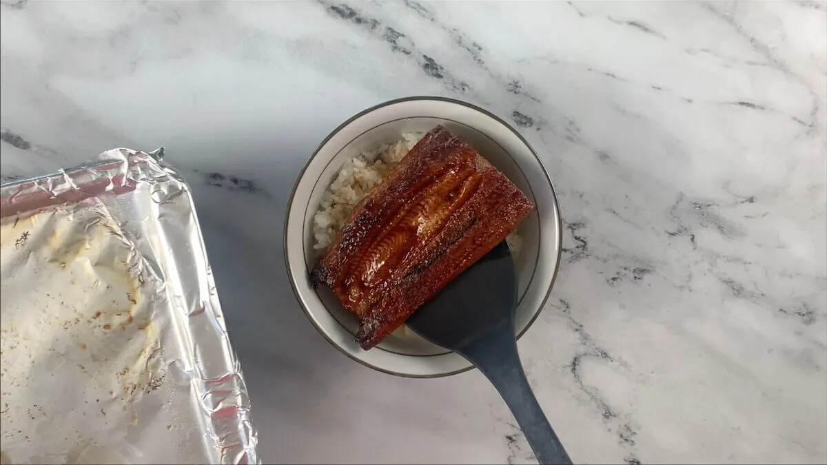 After the eel is done broiling, place into the rice bowl skin side down.