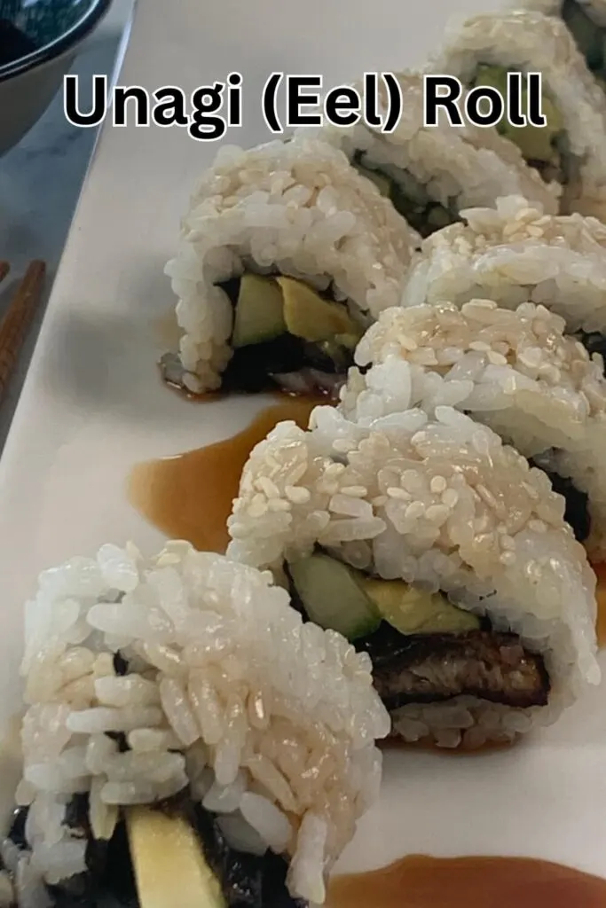 Unagi (eel) rolls displayed vertically on a white sushi plate