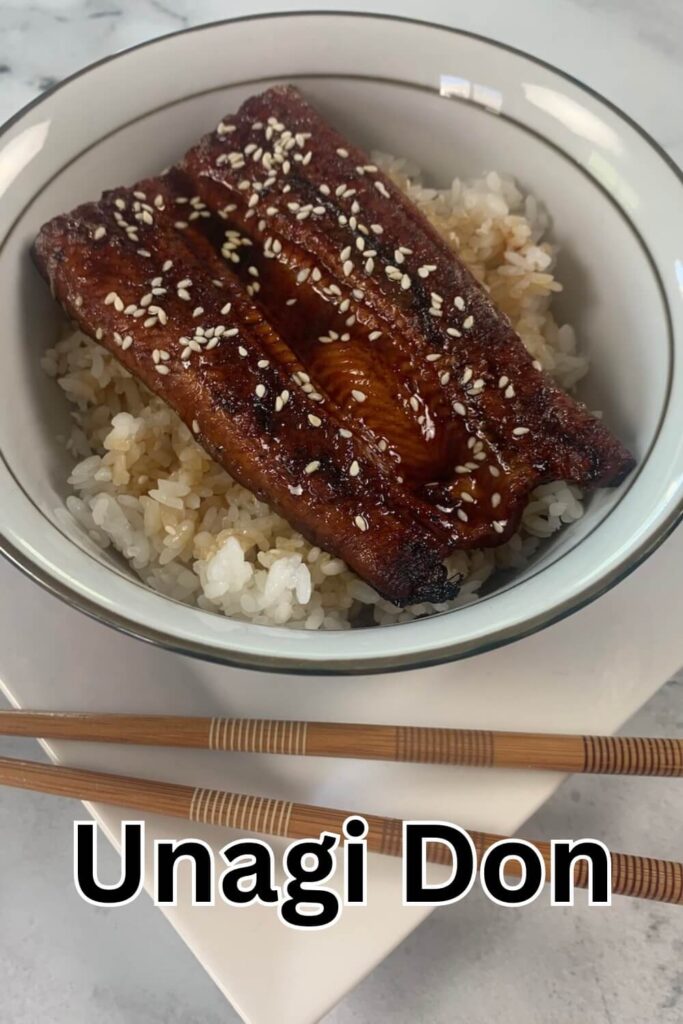 Unagi don (eel rice bowl) garnished with sesame seeds and served in a Japanese bowl.