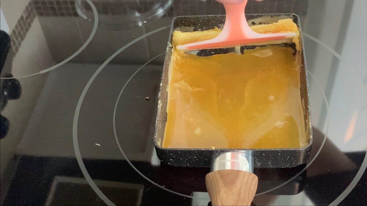 Add the second layer of seasoned egg to the pan lifting up the first layer to assure that the egg covers the entire bottom of the pan.