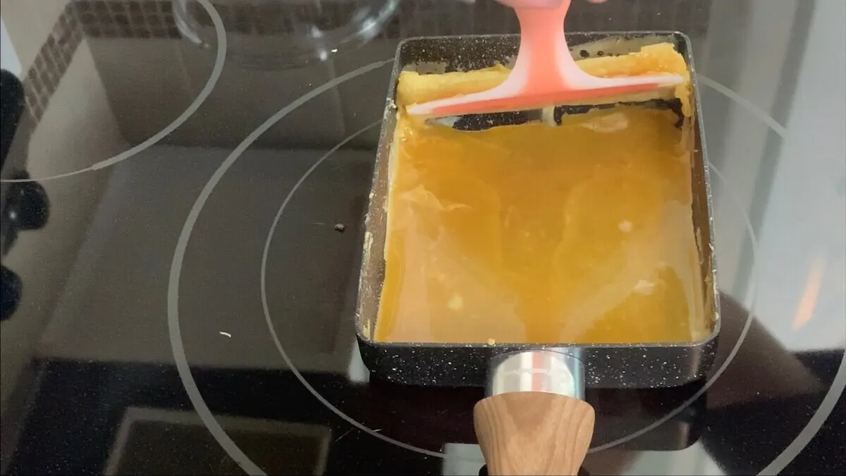 Add the second layer of seasoned egg to the pan lifting up the first layer to assure that the egg covers the entire bottom of the pan.