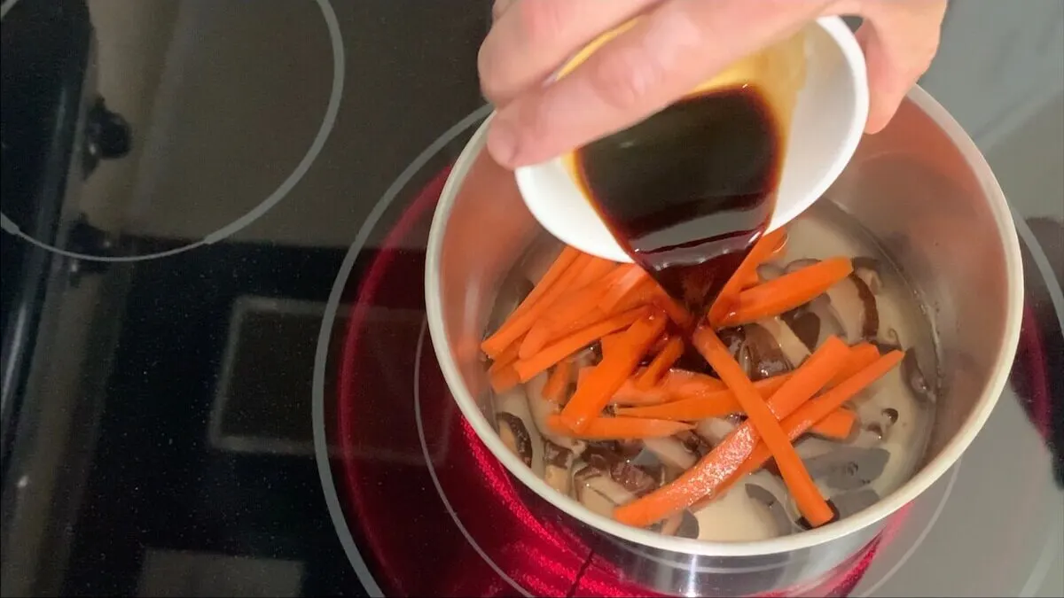 Add soy sauce to mushrooms and carrots.