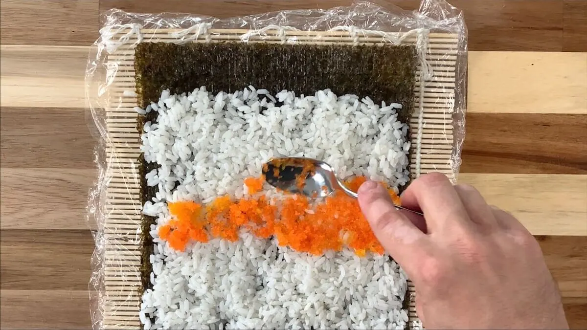 Spread masago onto the sushi rice.